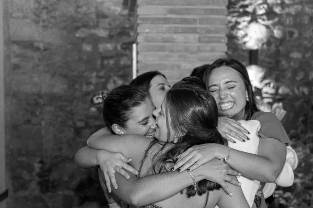 Tres amigas abrazándose y riendo durante la celebración