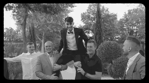Novio levantado en brazos por sus amigos durante la celebración de la boda